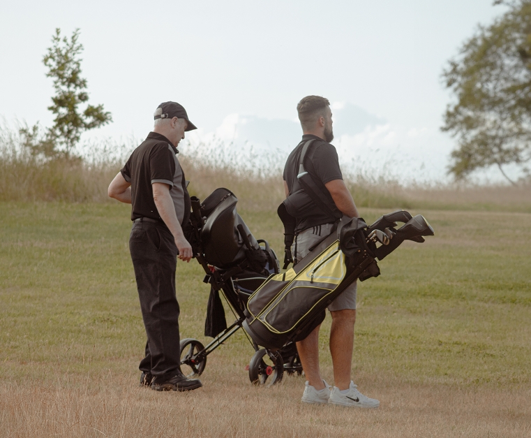 View of two gentleman playing golf with the Fable Golf Branding