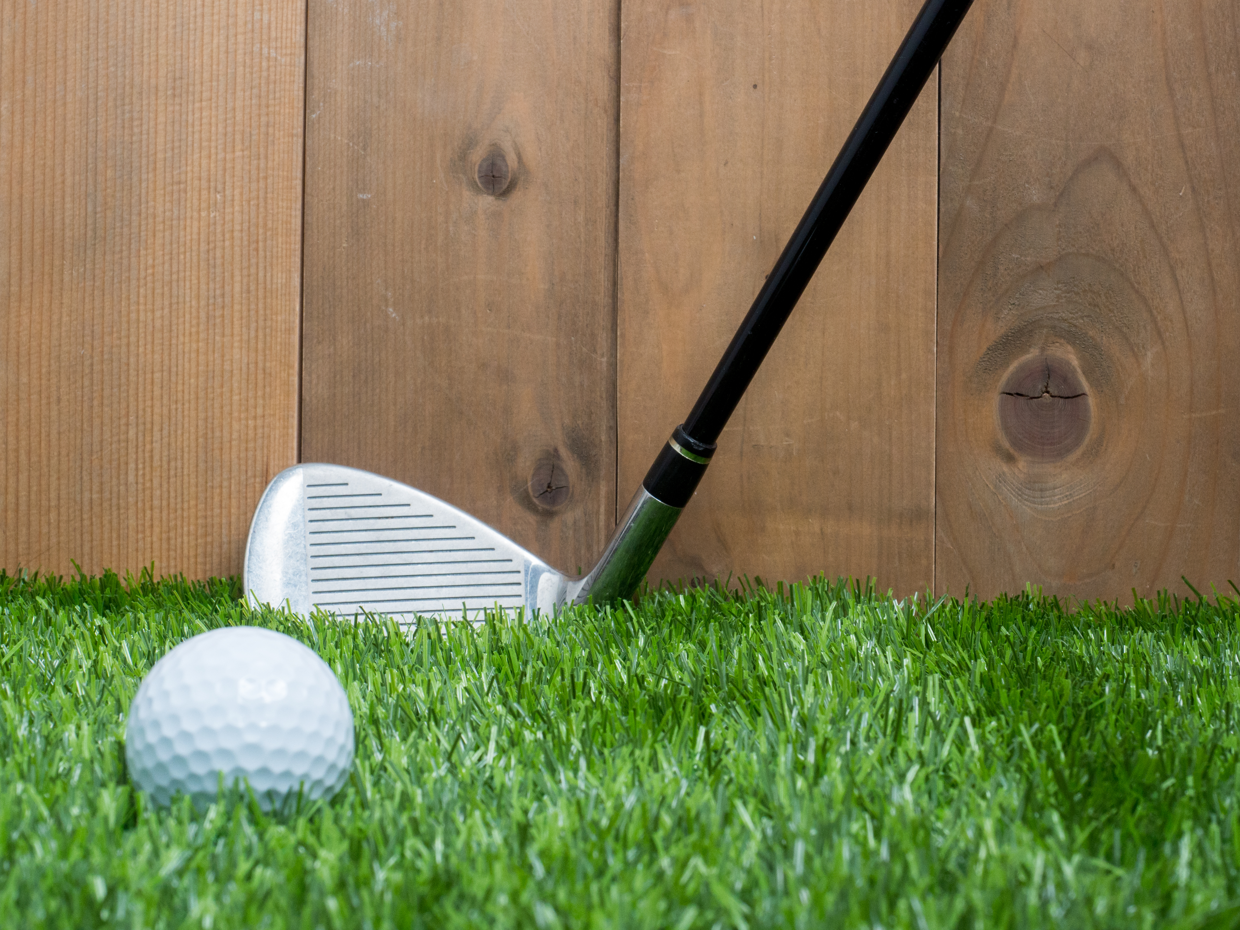 Golf and ball on green grass and wood background